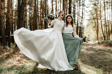 Tender bride with smiling bridesmaids dressed in long elegant dresses,bridesmaids with happy bride...
