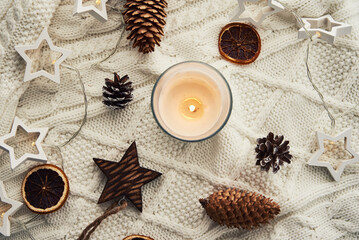 Burning candle and christmas decorations, top view. Winter cozy home and hygge concept