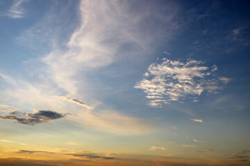 Sky blue and orange light of the sun through the clouds in the sky.