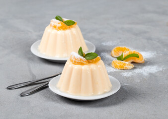 Panna cotta creamy tangerine on a plate on a light gray background