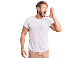 Young caucasian man wearing casual white tshirt shouting and screaming loud to side with hand on mouth. communication concept.