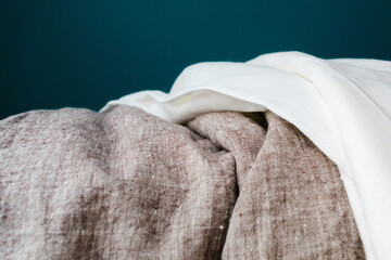 Linen fabric on dark turquoise background. natural fabric rolls. various linen colors