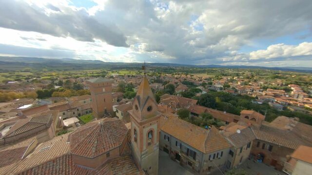 Village of Bettolle, Sinalunga. The town from above, surrounded by the green Tuscan hills. Aerial fpv drone