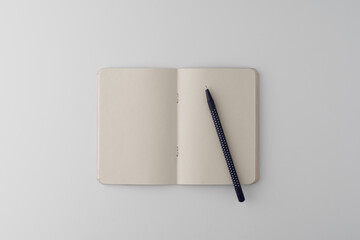 An empty craft notebook and pen on a white background. Layout. Stylized stock photos. The view from the top. Mock-up.