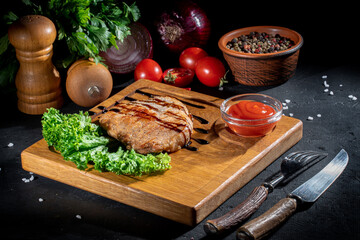 Grilled ribeye beef steak, herbs and spices on dark background