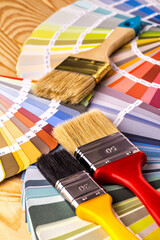 Color palette guide and brushes on wooden desktop