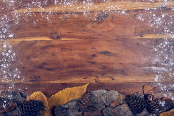 A nice wooden background with dried leaves and pine cones