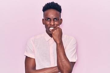 Obraz premium Young african american man wearing casual clothes looking stressed and nervous with hands on mouth biting nails. anxiety problem.