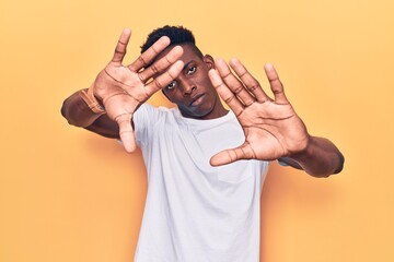 Young african american man wearing casual clothes doing frame using hands palms and fingers, camera perspective