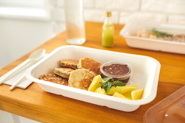 Healthy delicious dessert of pancakes with chocolate pudding and sliced fruit in takeaway container