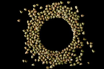 Buckwheat pile isolated on black background, top view