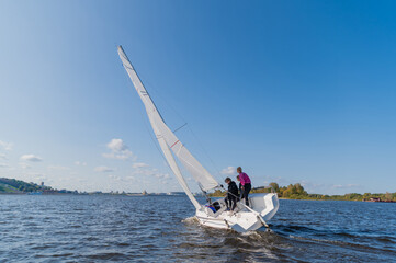 Dad and his two daughters went out on a yacht on the river to sail along the city, and teach the girls to conduct a sports yacht