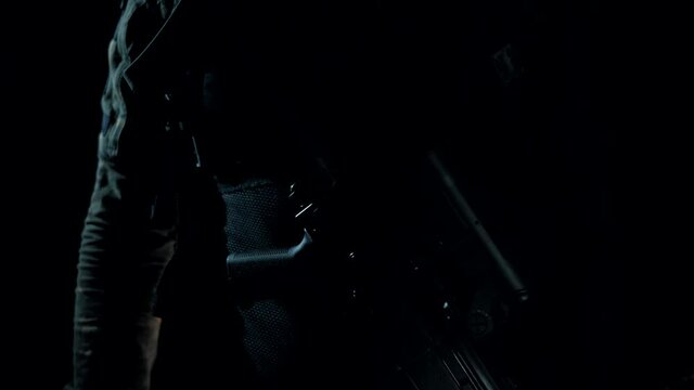 Man in a multicam on a black background holds an AK in his hands