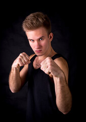 Young sportsman makes boxing exercises studio portrait