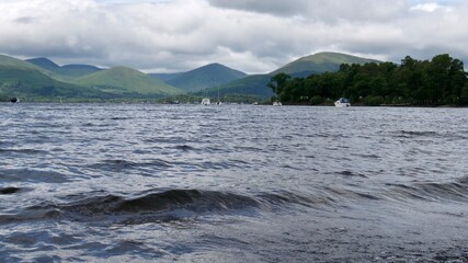 Waves on surface of a lake with mountains in the background