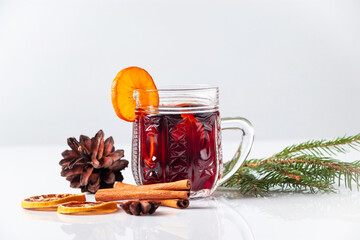Winter warming mulled wine in glass cup on white background.