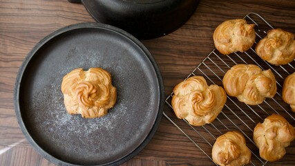 Freshly baked delicate flower shaped golden pastry on a plate ready to be cut and filled 