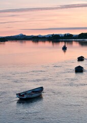 Fishing boats on river Forth during sunset in Alloa harbour overlooking Stirling Castle and Scottish hills 