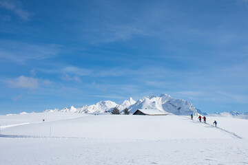 
Four people hiking on snowshoes in the deep snow in the alps