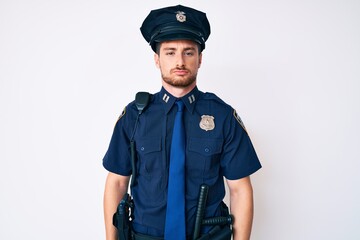 Young caucasian man wearing police uniform looking sleepy and tired, exhausted for fatigue and hangover, lazy eyes in the morning.