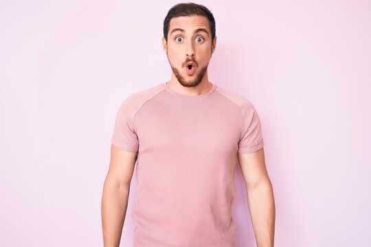 Young handsome man wearing casual tshirt scared and amazed with open mouth for surprise, disbelief face