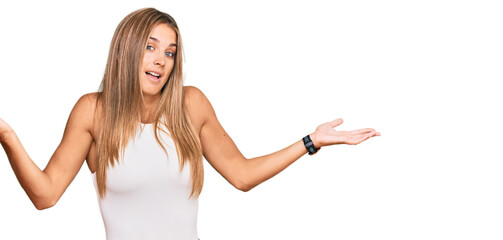 Young blonde woman wearing casual style with sleeveless shirt clueless and confused expression with...