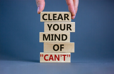 You can. Wooden blocks with words 'clear your mind of can not'. Male hand. Beautiful grey background, copy space. Business and motivational concept.
