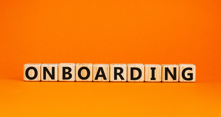 Time to onboarding. 'Onboarding' written on wooden blocks. Business and onboarding concept. Beautiful orange background. Copy space.