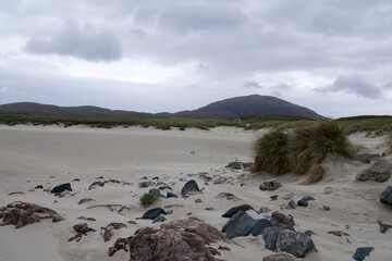 White beach on a Scottish coastline with rocks and hills in the background, Outer Hebrides