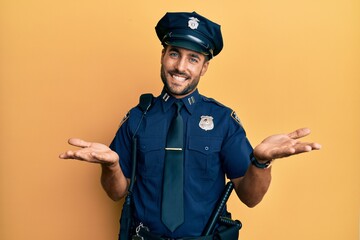 Handsome hispanic man wearing police uniform smiling cheerful offering hands giving assistance and acceptance.