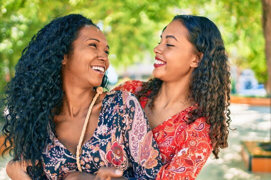 African american mother and daughter smiling happy hugging at the park.