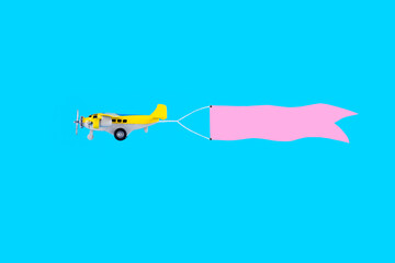 Airplane with banner for text on pastel blue background