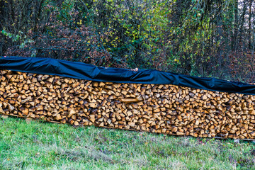 Mit einer Abdeck Plane geschützter Brennholz Stapel