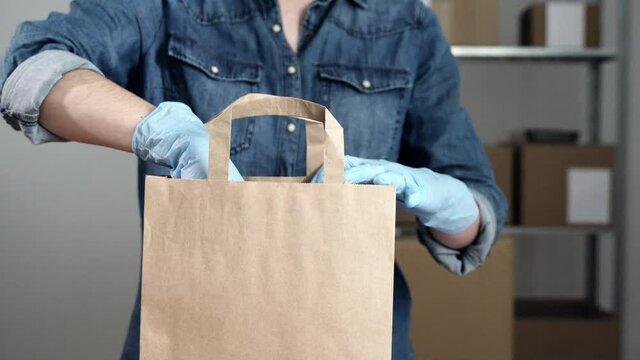 Female Small Business Owner Preparing Dropshipping Cardboard Bag For Ship Order During Coronavirus Outbreak 