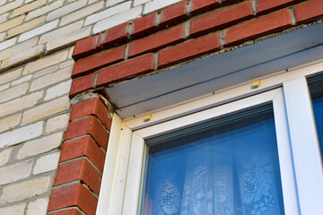 Plastic Euro window in a red and white brick house