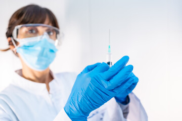 Female doctor with coronavirus vaccine injection. Antibodies, immunize population. side effects, risk people, antibodies, new normal, covid-19.