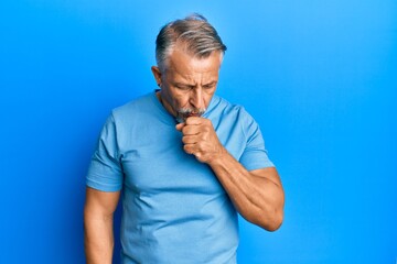 Middle age grey-haired man wearing casual clothes feeling unwell and coughing as symptom for cold...
