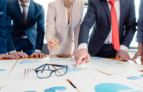 Team of business people analyzing numbers and charts