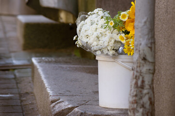 A bouquet of flowers in a bucket on the street