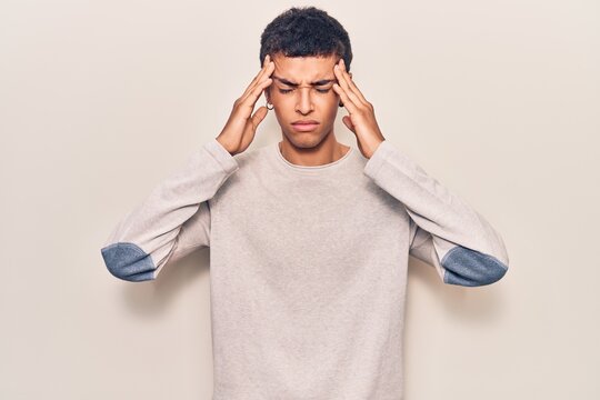 Young african amercian man wearing casual clothes suffering from headache desperate and stressed because pain and migraine. hands on head.