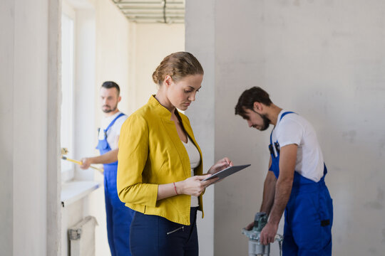 Famele brigadier evaluate the work of repairers and write in the clipboard