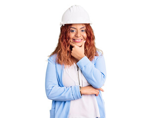 Young latin woman wearing architect hardhat looking confident at the camera smiling with crossed arms and hand raised on chin. thinking positive.