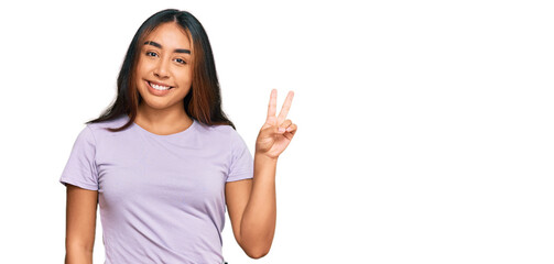 Young latin woman wearing casual clothes showing and pointing up with fingers number two while smiling confident and happy.