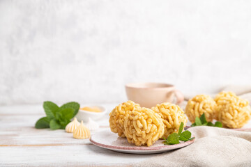 Traditional Tatar candy chak-chak made of dough and honey with cup of coffee on a white wooden background. Side view, copy space, selective focus.
