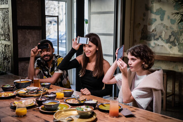 Smiling teenage friends playing a word-guessing game at the dinner party.