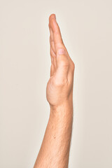 Hand of caucasian young man showing fingers over isolated white background showing the side of stretched hand, pushing and doing stop gesture