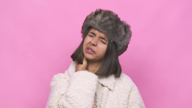 Young hispanic woman wearing a winter hat face closeup confused, feels doubtful and unsure