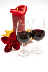 Popular british christmas drink, glass of vintage ruby port wine and candle with christmas tree decoration