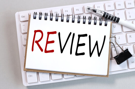 review, text on white paper on white keyboard on gray background