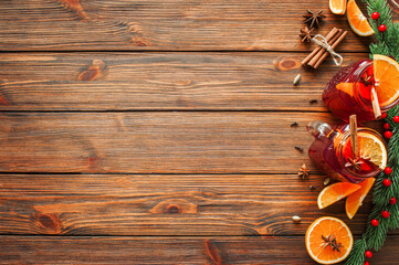 Background from wooden boards with a winter drink mulled wine and ingredients, decorated with fir branches. Place for text, copy space
